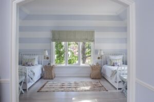 dormitorio dos camas y pared de rayas en azul suave AD